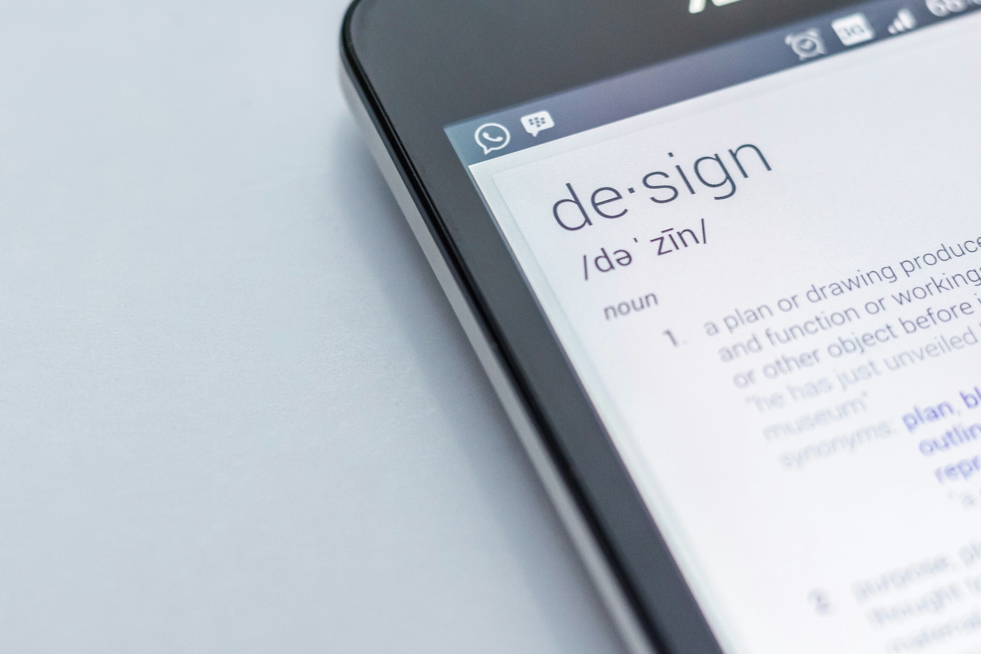 a close up of a cell phone with the word design on the screen .