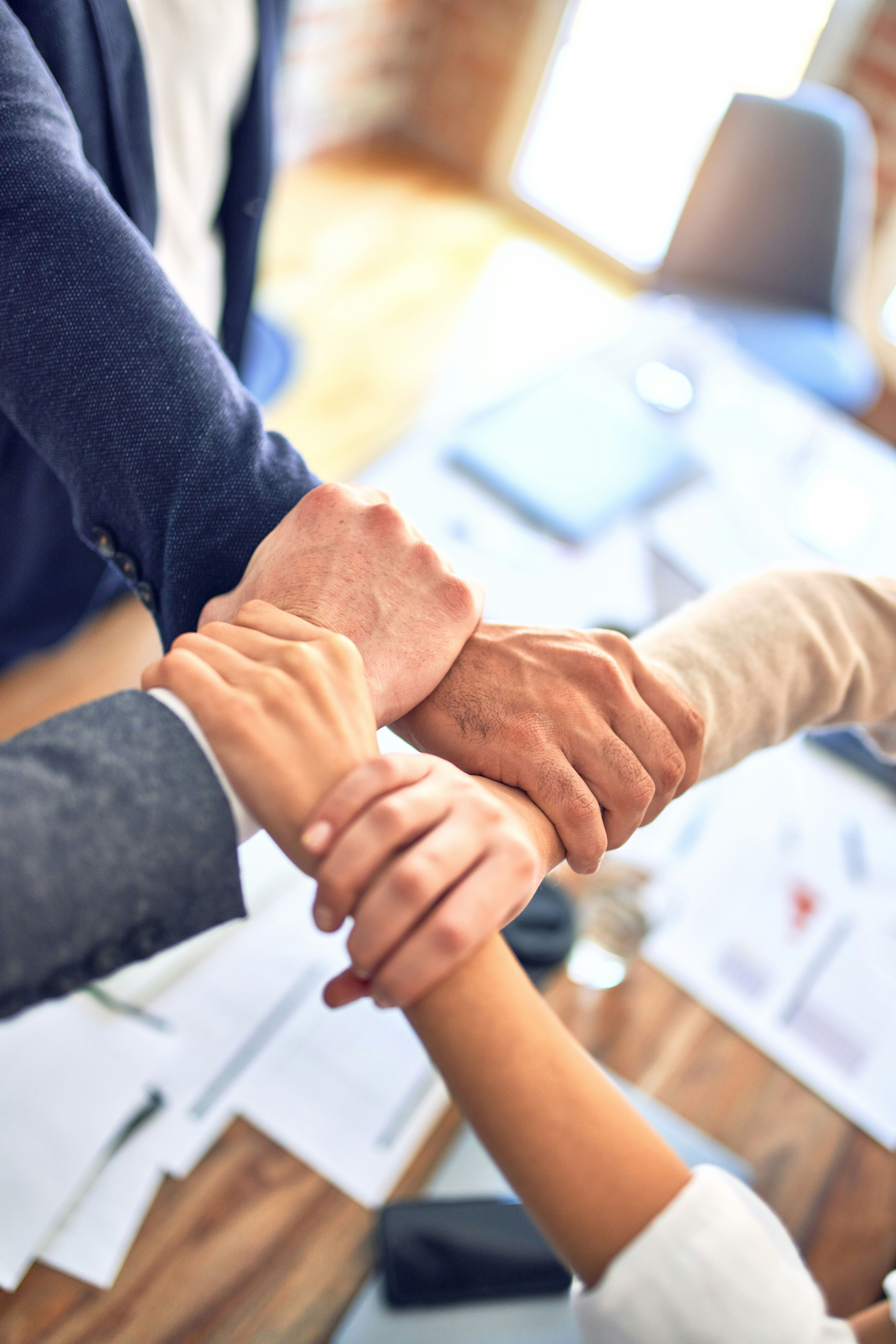 a group of people are putting their hands together
