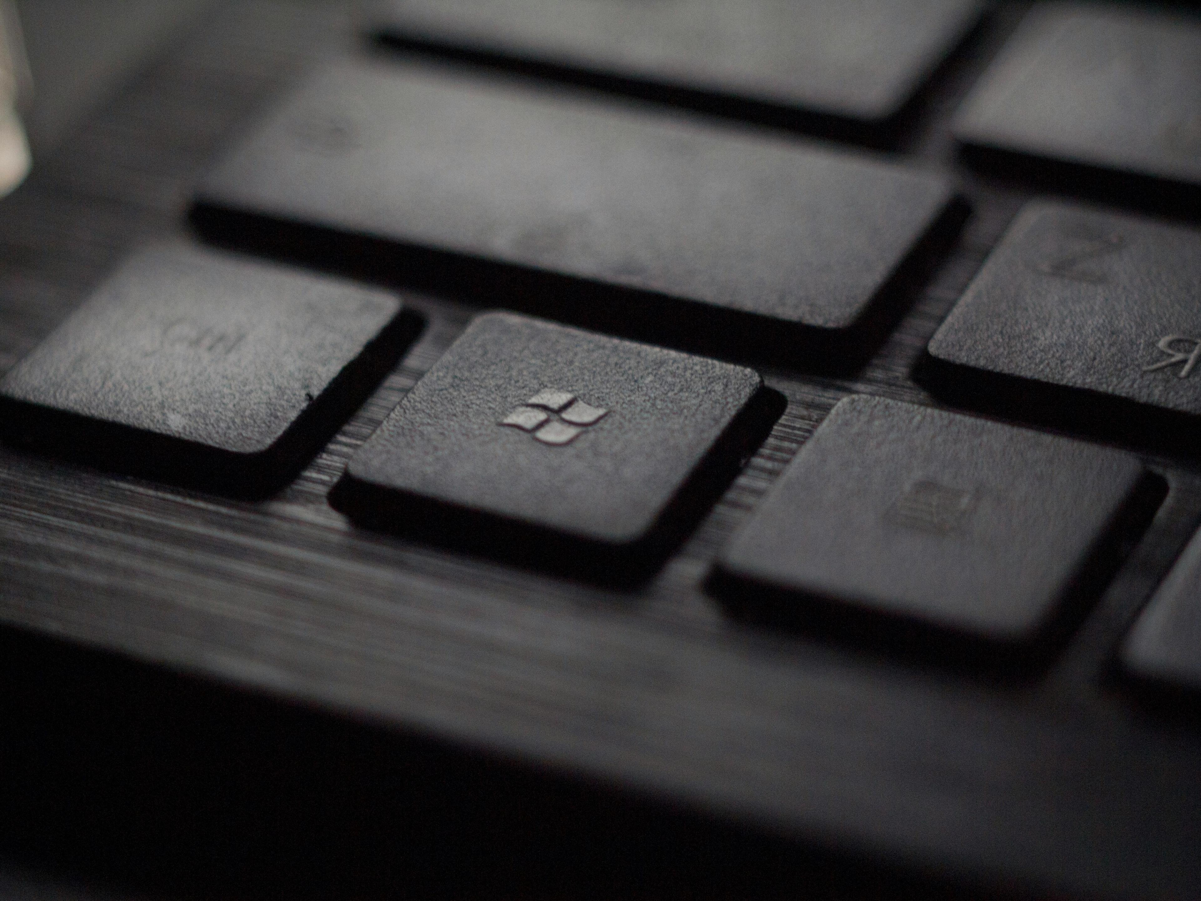 a close up of a black keyboard with a windows key on it .