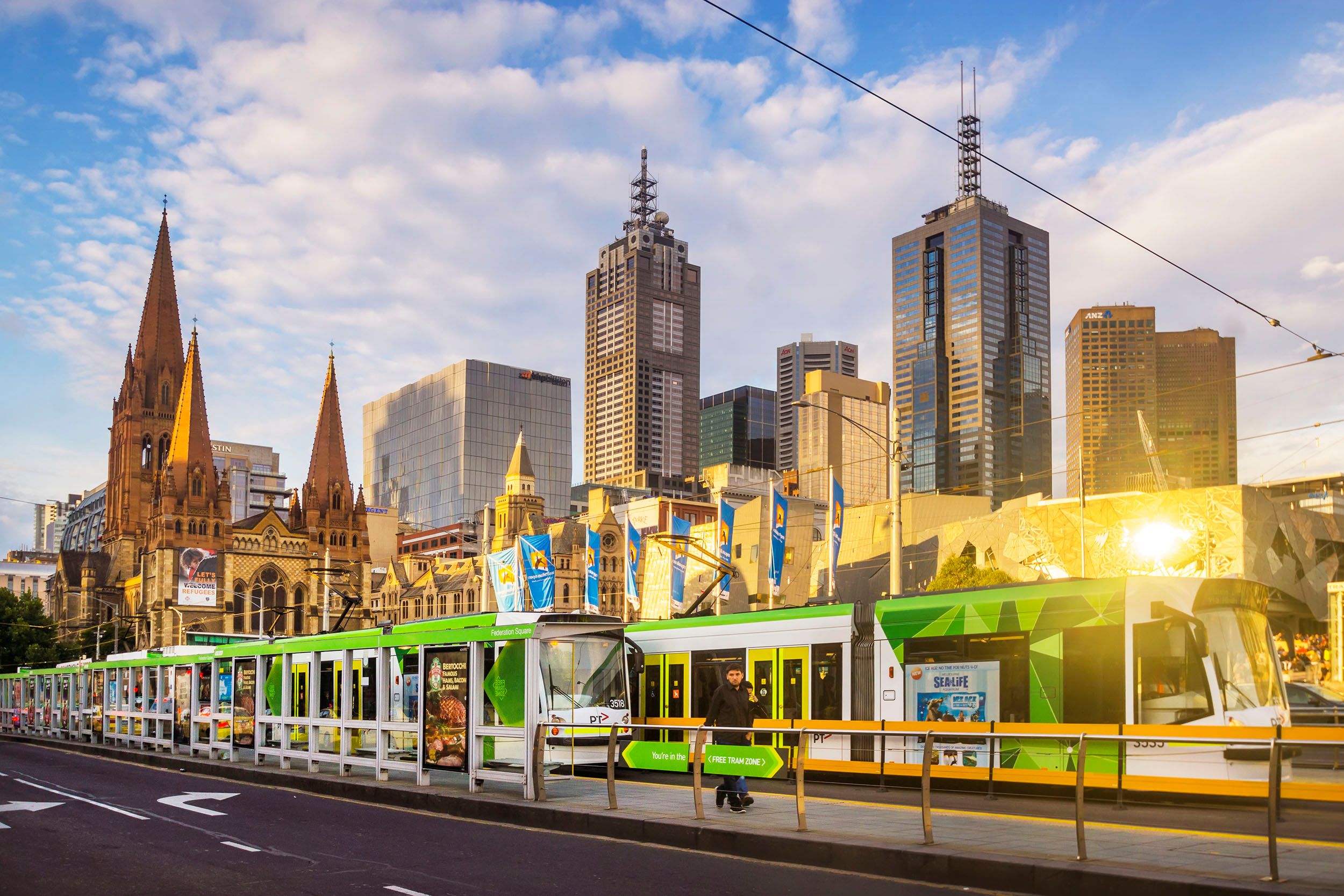 a train is pulling into a station in a city with a city skyline in the background .
