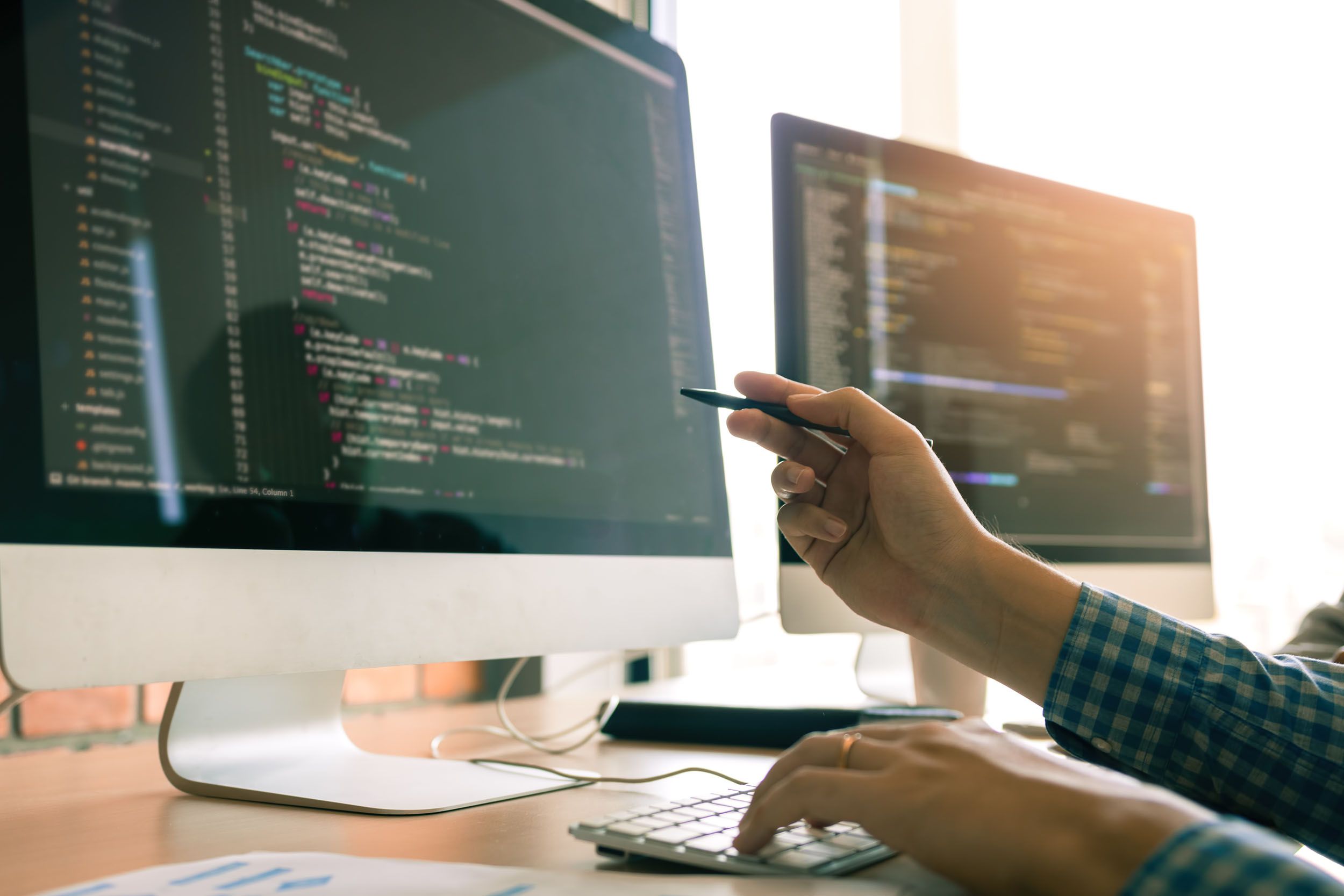 a man is sitting at a desk working on a computer .