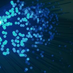 a bunch of blue dots are floating in the air on a dark background .