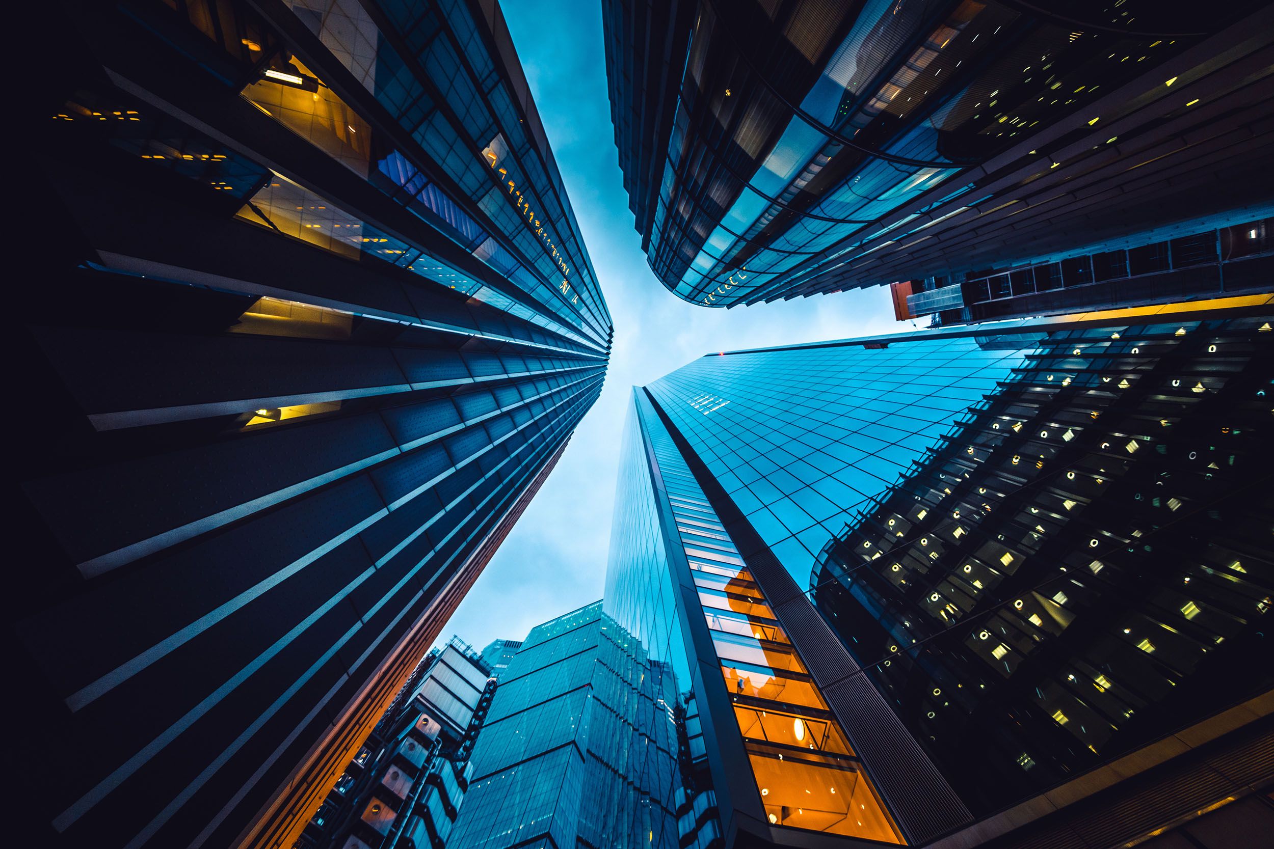 looking up at tall buildings in a city at night .