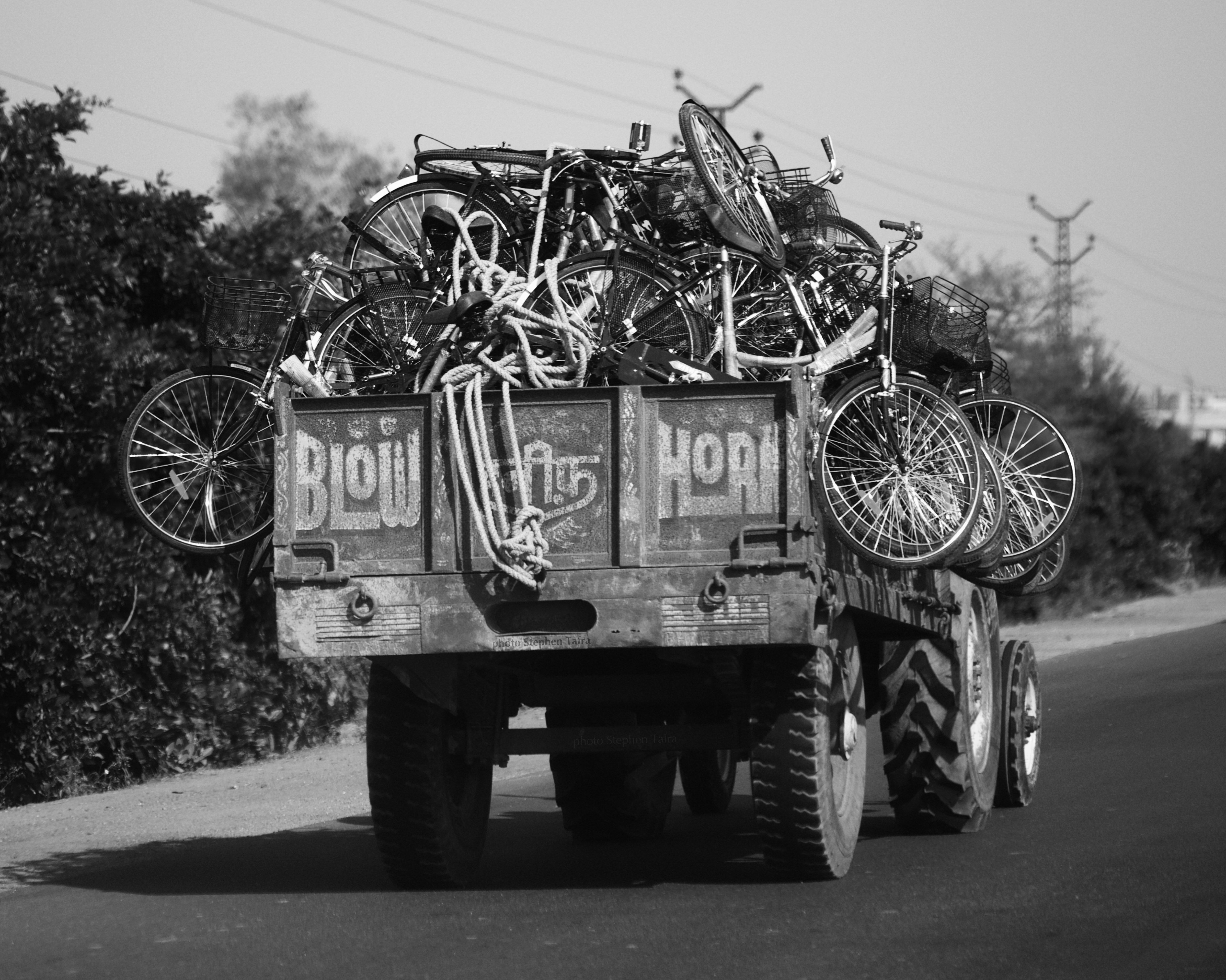 a black and white photo of a trailer filled with bicycles .