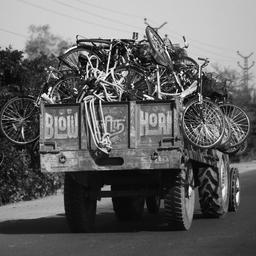 a black and white photo of a trailer filled with bicycles .