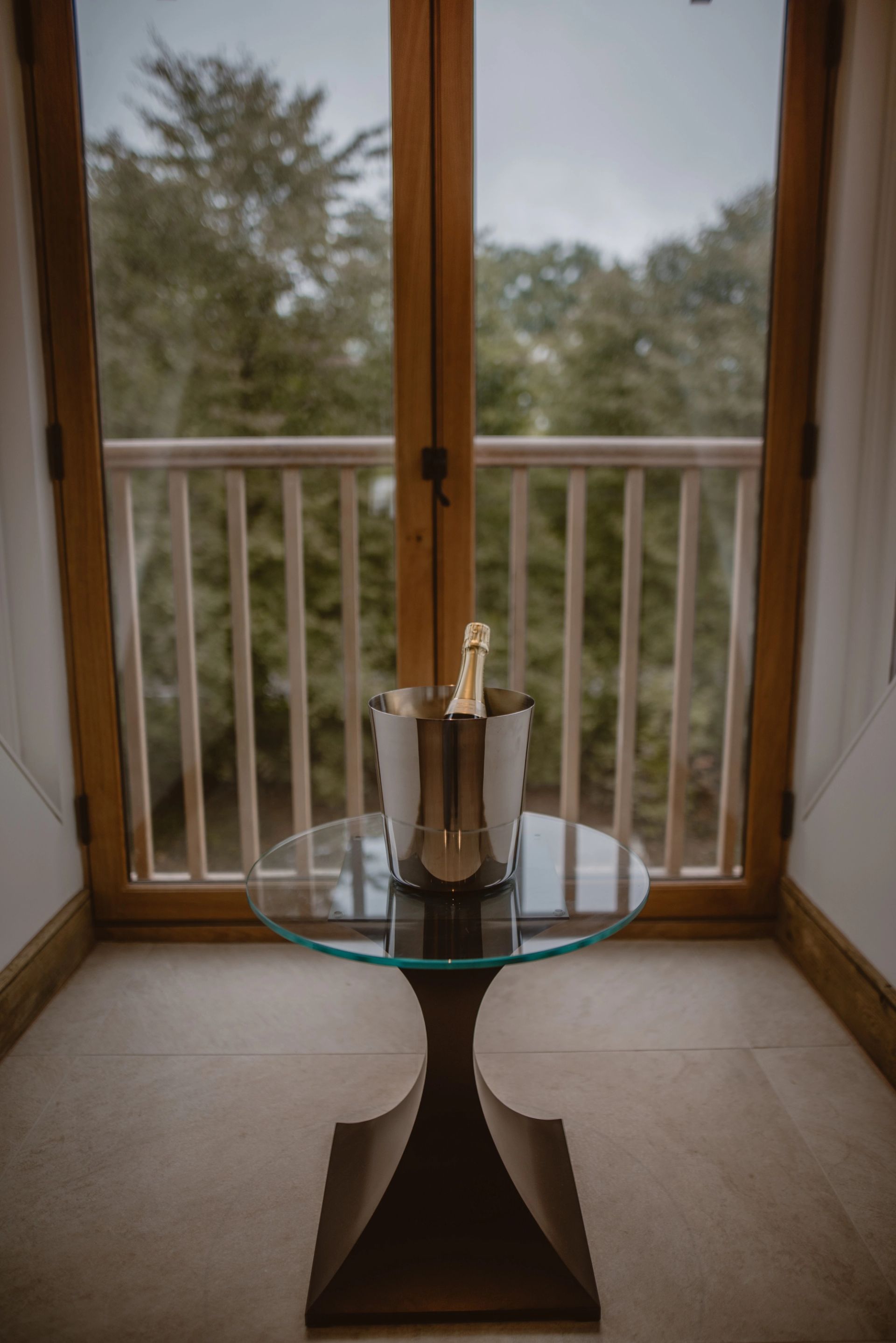 Glass table with wine bucket and balcony doors