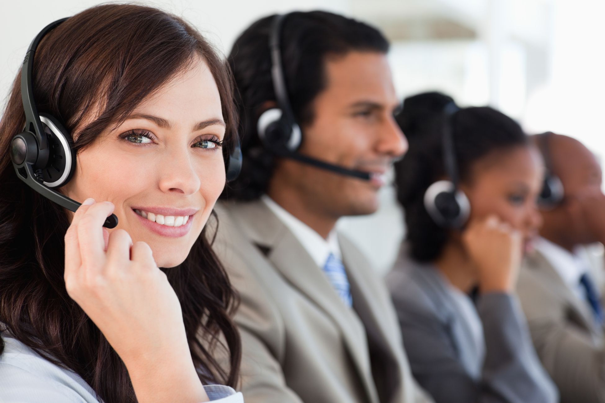 2 men and 2 women with headsets on offering customer support
