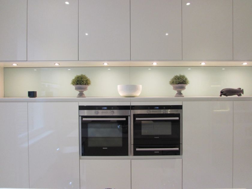 gloss kitchen units with built in appliances and ornaments