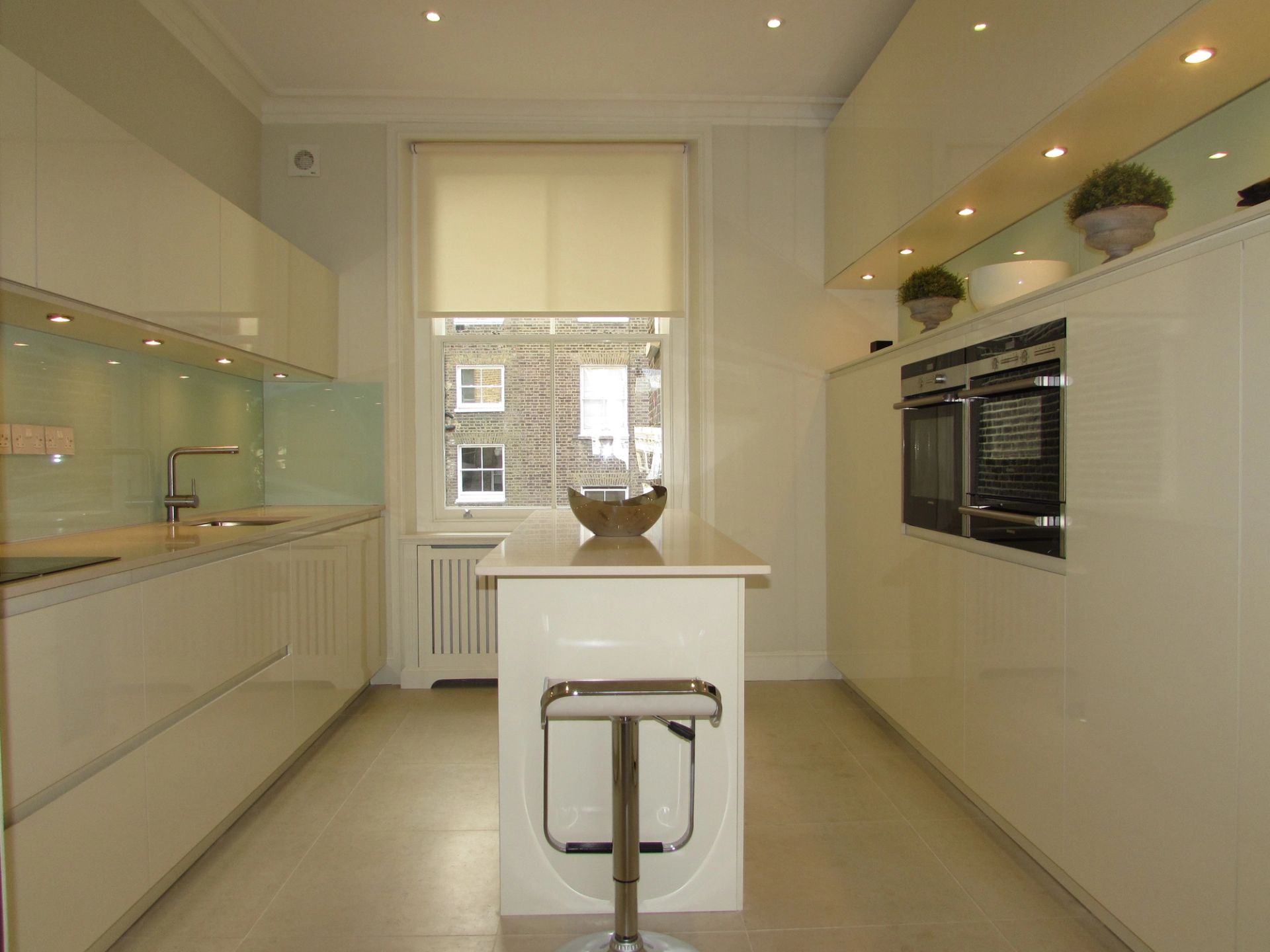 Kitchen with island in the middle and worktop to the left and cupboard to the right