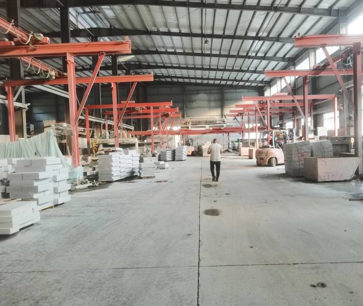 Natural granite processing factory workshop with stone machinery and lifting systems for batch production of granite slabs, cobblestones, kerbstones and custom project stone.