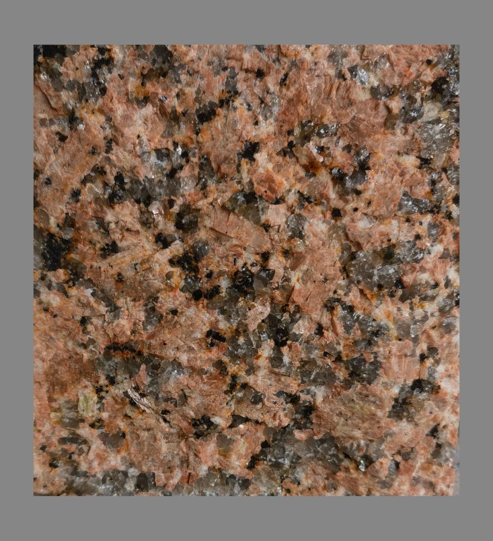 Imperial Sunset granite cobblestone sample with reddish brown sunset tones for luxury resort driveway paving.