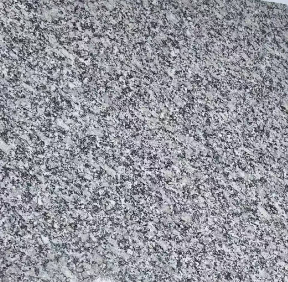 Haiti Grey polished granite slab with wavy grey and white patterns for commercial lobby flooring and walls.