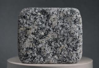 Haiti Grey Granitpflasterstein mit Antik-Finish, grau-weißer Kristallstruktur, dunklen Mineralkörnungen und weich abgerundeten, gealterten Kanten.