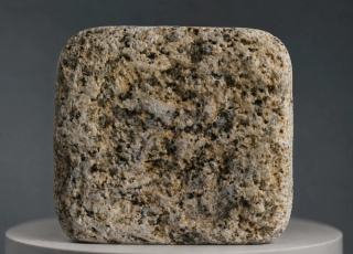 Golden Sesame Granitpflasterstein mit getrommeltem Antik-Finish, abgerundeten Kanten und natürlicher beige-goldener, grauer und dunkler Mineralkörnung.