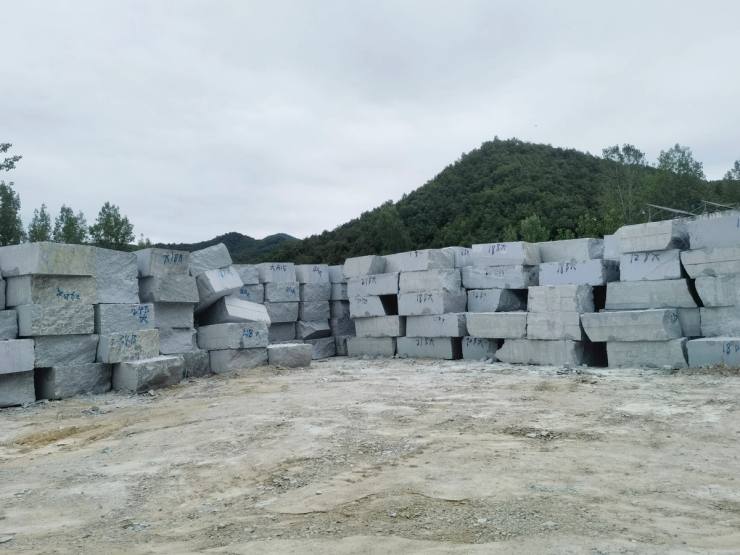 Natural granite quarry blocks stored by production batch, providing stable raw material supply for granite cobblestones, kerbstones and project paving slabs.