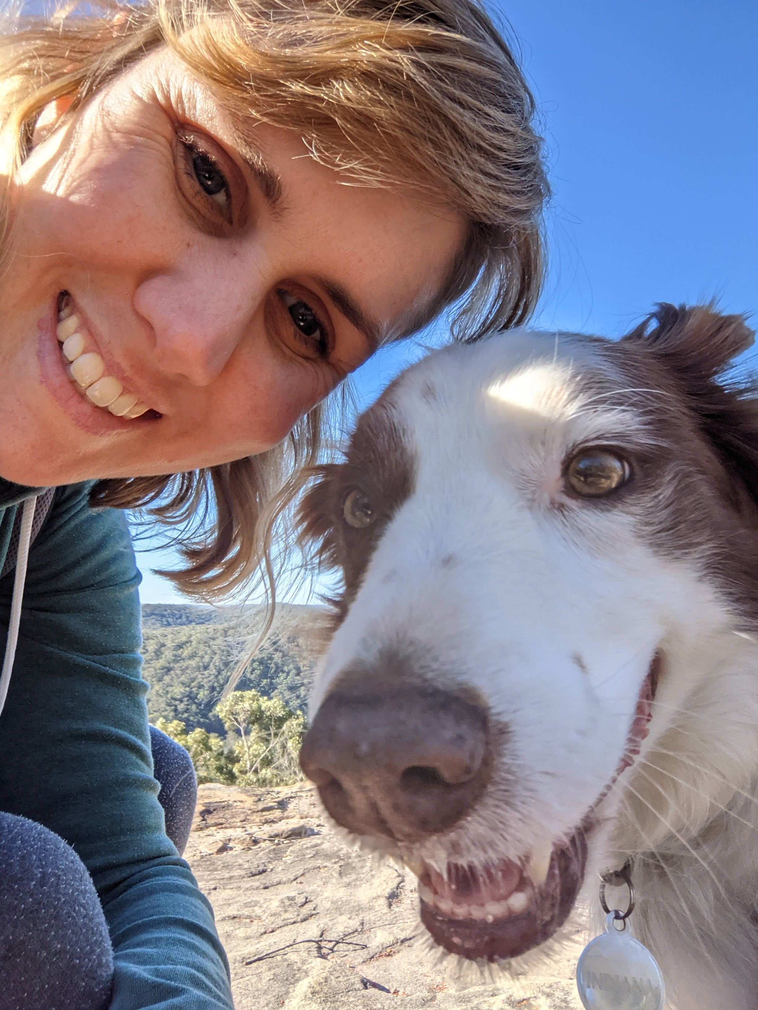 A photo of April with her dog at the beach 