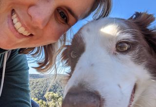 A photo of April with her dog at the beach