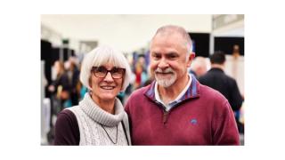 A couple pose for a photo at a Senior's expo.