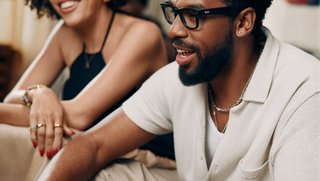 Man wearing meta smart glasses talking with a friend on a couch