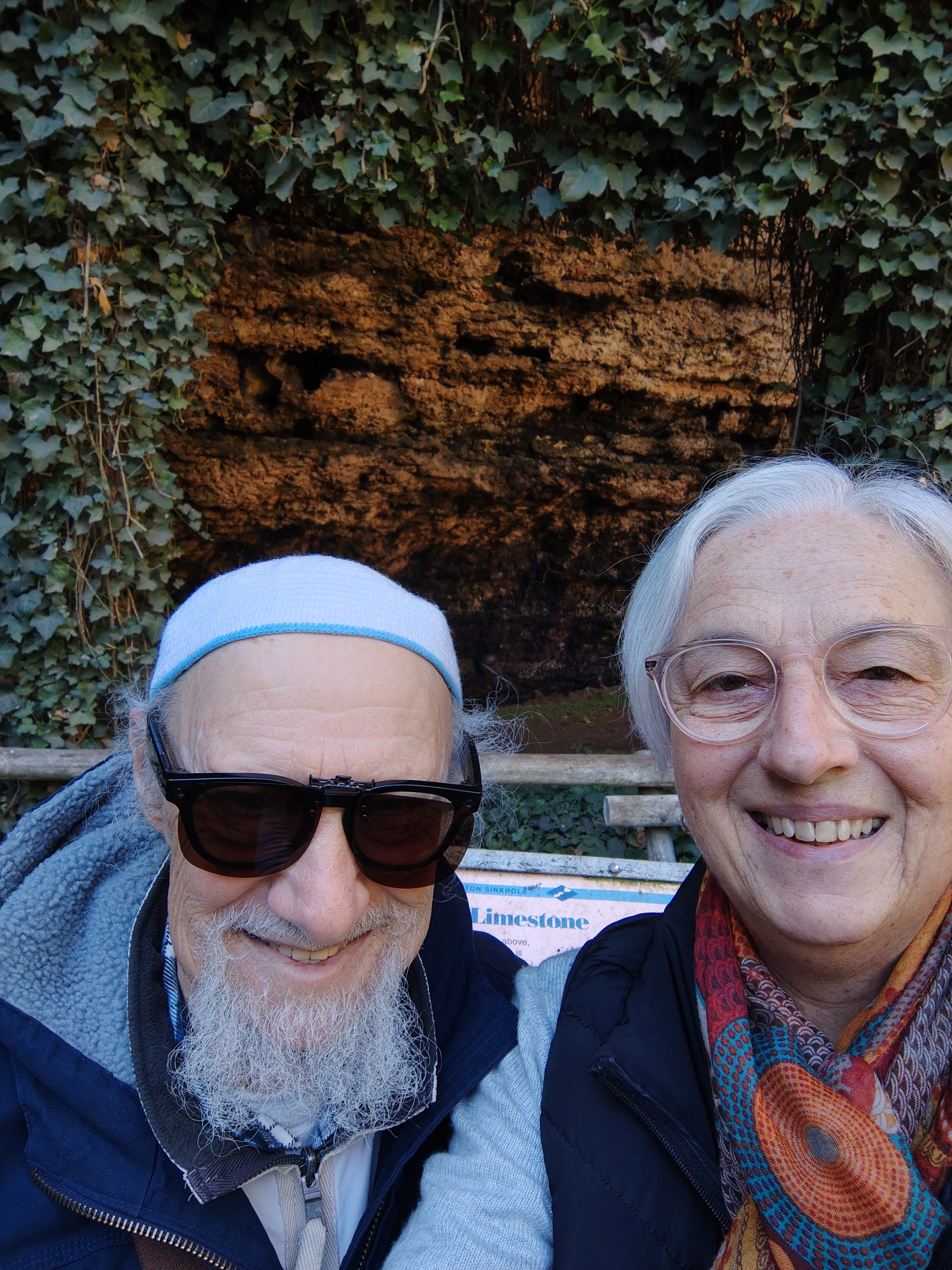Laurence and his wife pose for a selfie together in front of a rock formation.