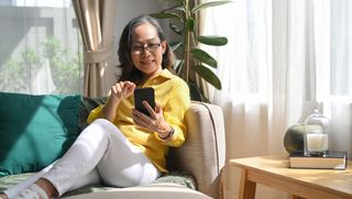 A woman using her phone on the couch.