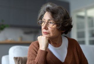 Pensive looking older person sitting at home