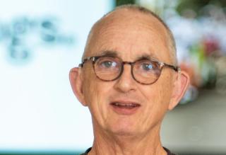 A photo of Alan wearing glasses and a black shirt