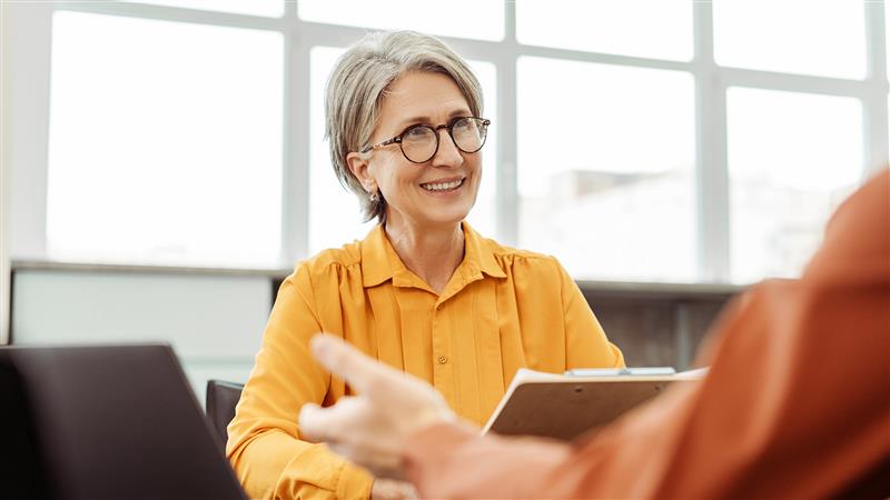 Older woman talking to co-worker.