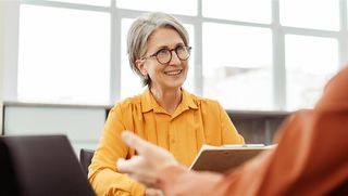 Older woman talking to co-worker.