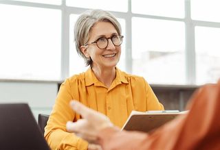 Older woman talking to co-worker.