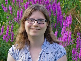 A headshot of Dr Coleman standing in a field of pink lavender.