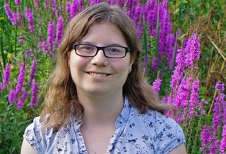 A headshot of Dr Coleman standing in a field of lavendar.