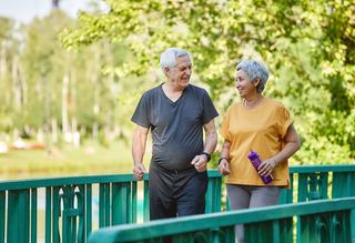 Older couple exercising by walking outside