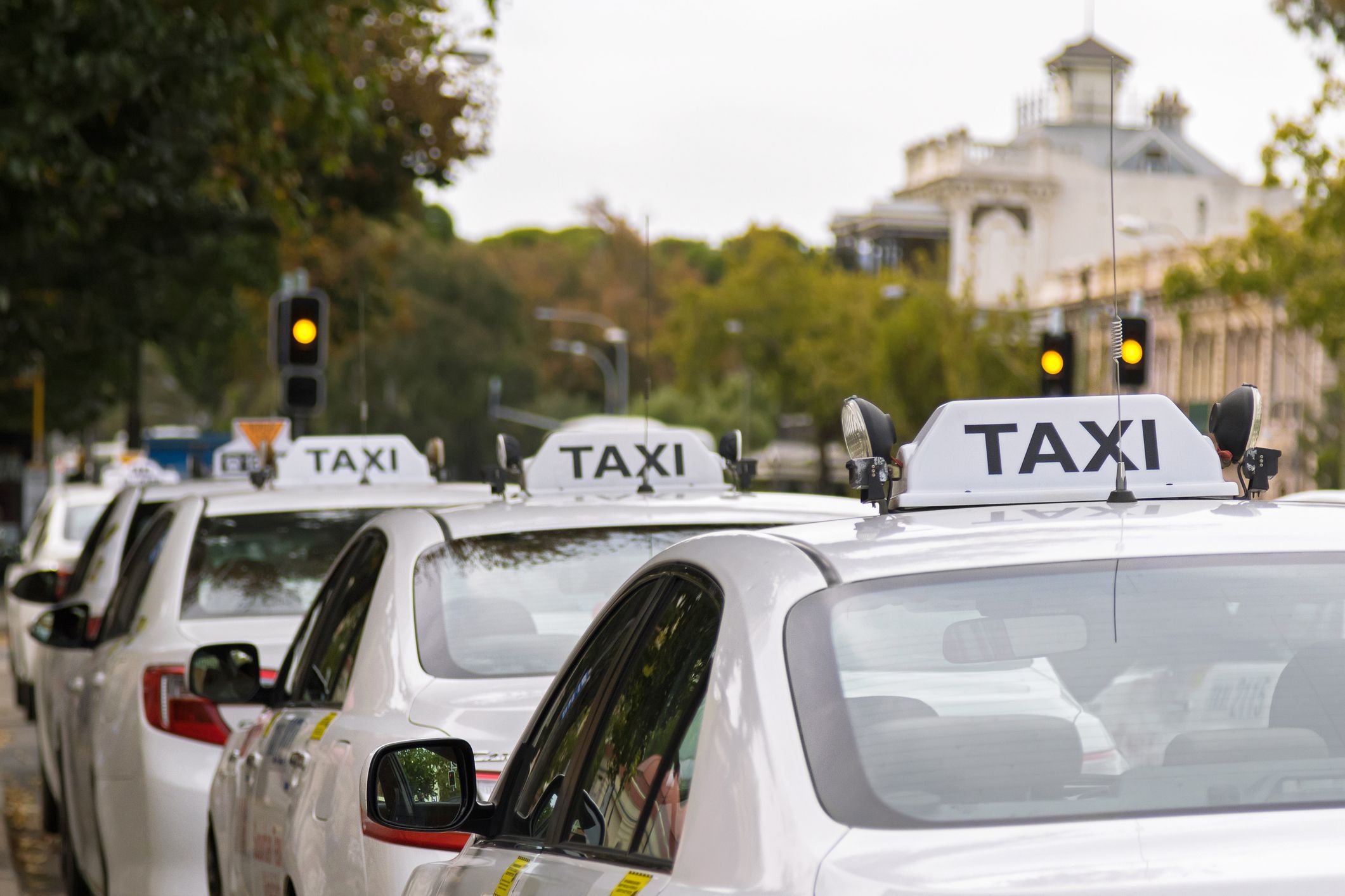 A row of Taxis parked on the street.