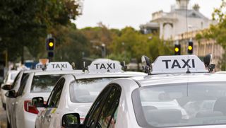 A row of Taxis parked on the street.
