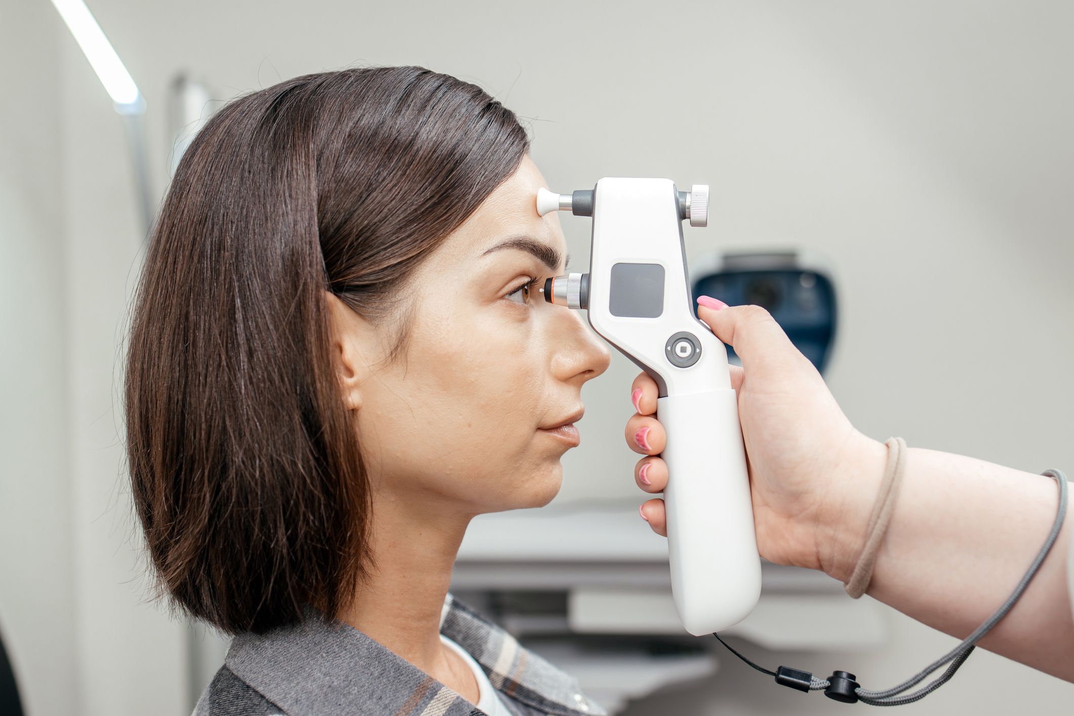 A woman having her intraocular pressure checked by an eye care professional.