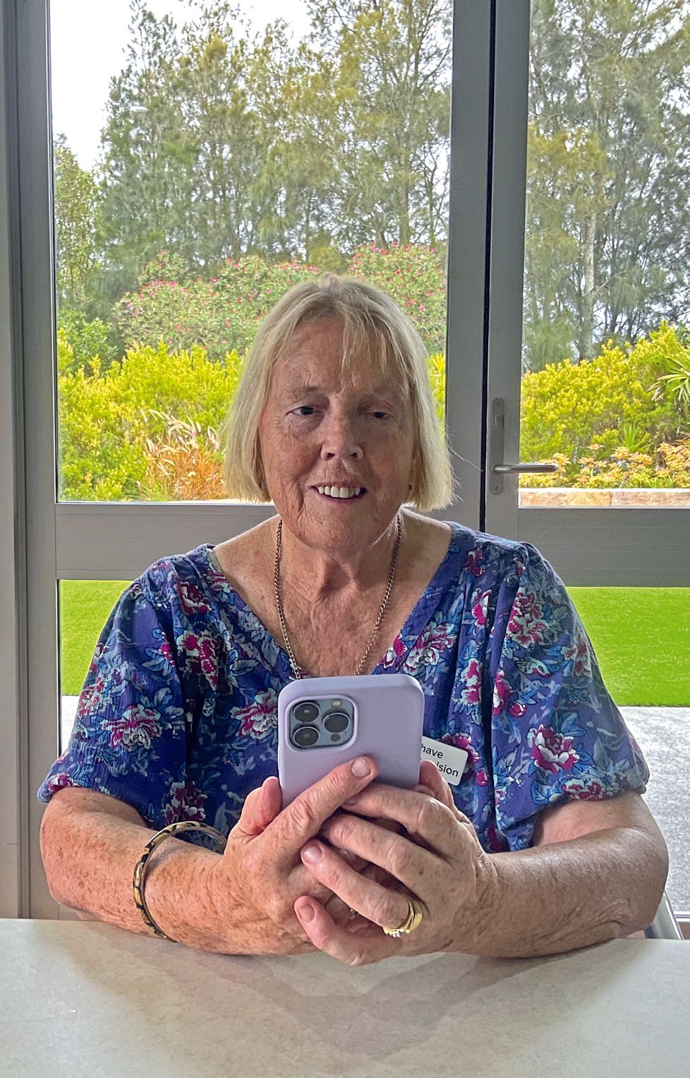 A photo of Angela wearing a blue dress and using her phone