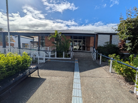The exterior of the Queensland Blind Association Building, with two pathways leading to the entrance, one with stairs and one ramp.