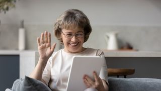 Older woman smiling while using a digital tablet