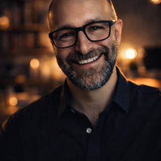 Pascal smiling in front of an orange and black background.