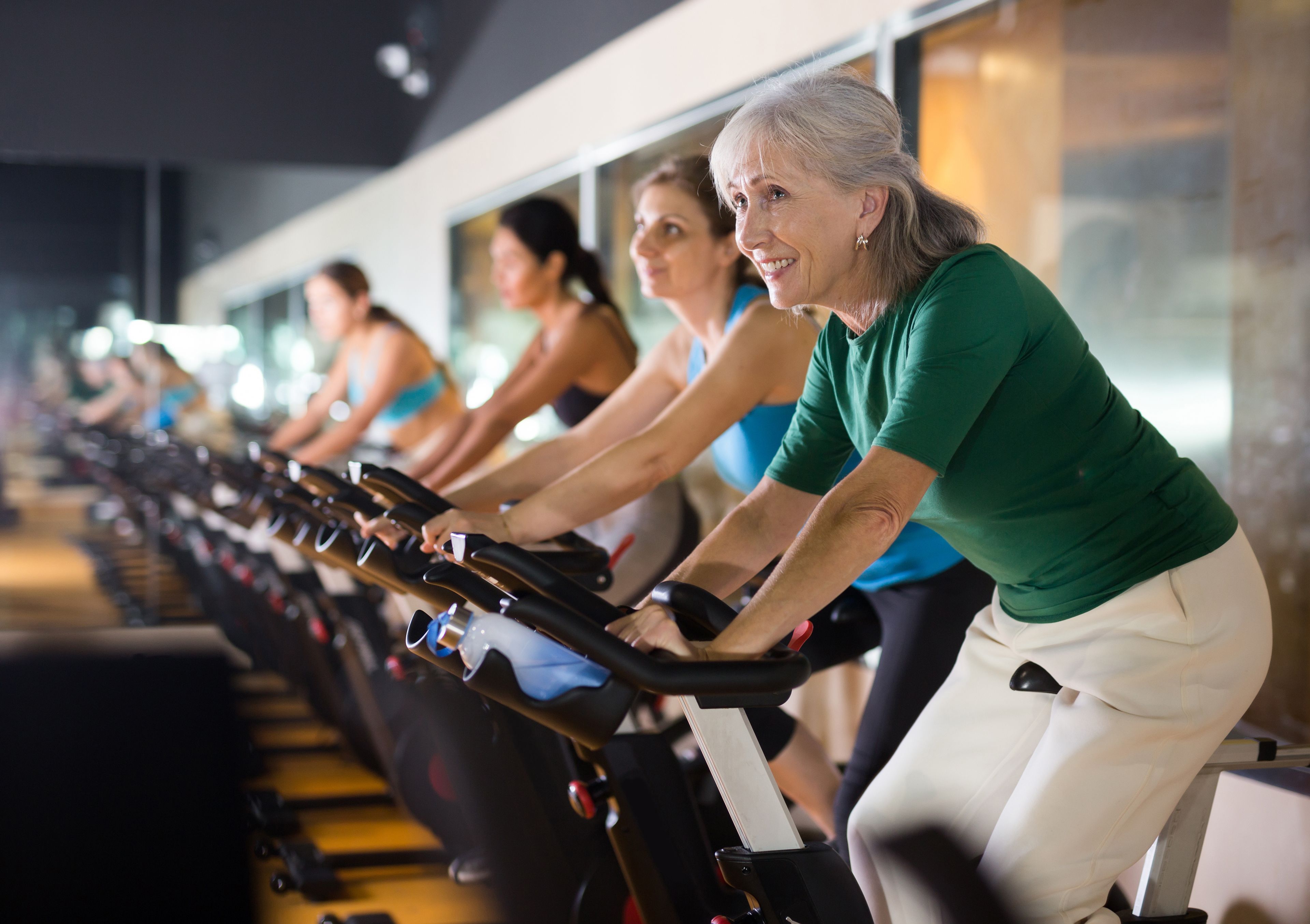 Older woman in gym taking cycling class