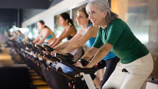 Older woman in gym taking cycling class