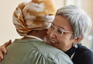 Close-up of two people hugging and smiling
