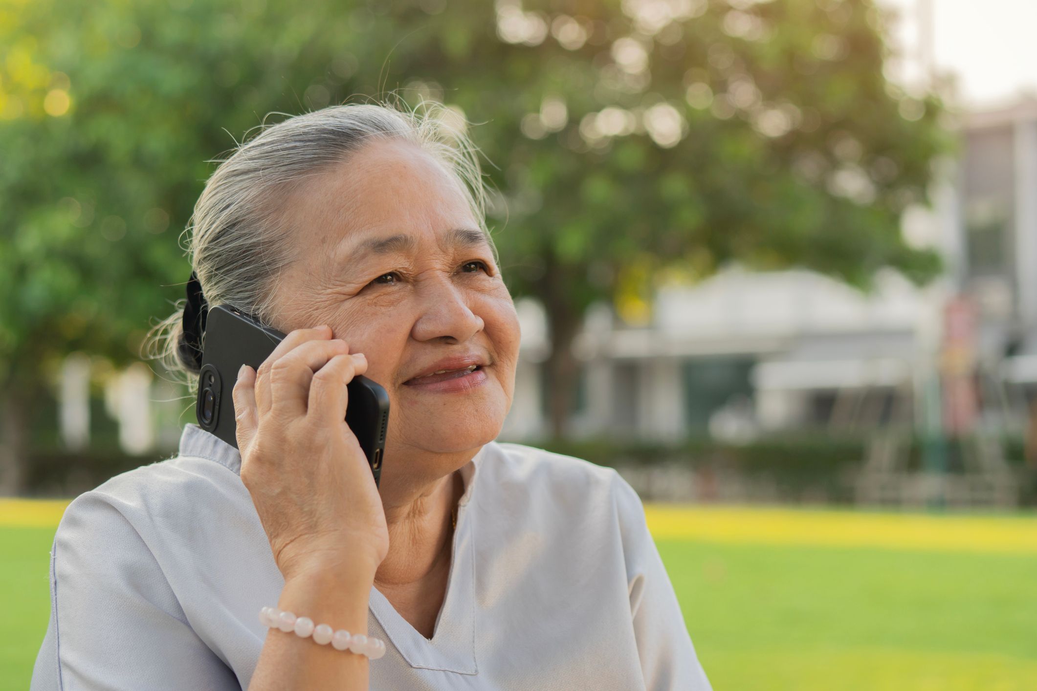 A woman talking on the phone outdoors.