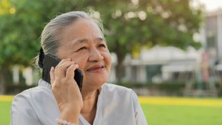 A woman talking on the phone outdoors.