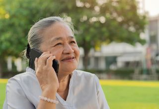 A woman talking on the phone outdoors.