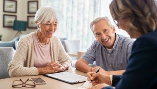 Older couple seated at a table with financial consultant