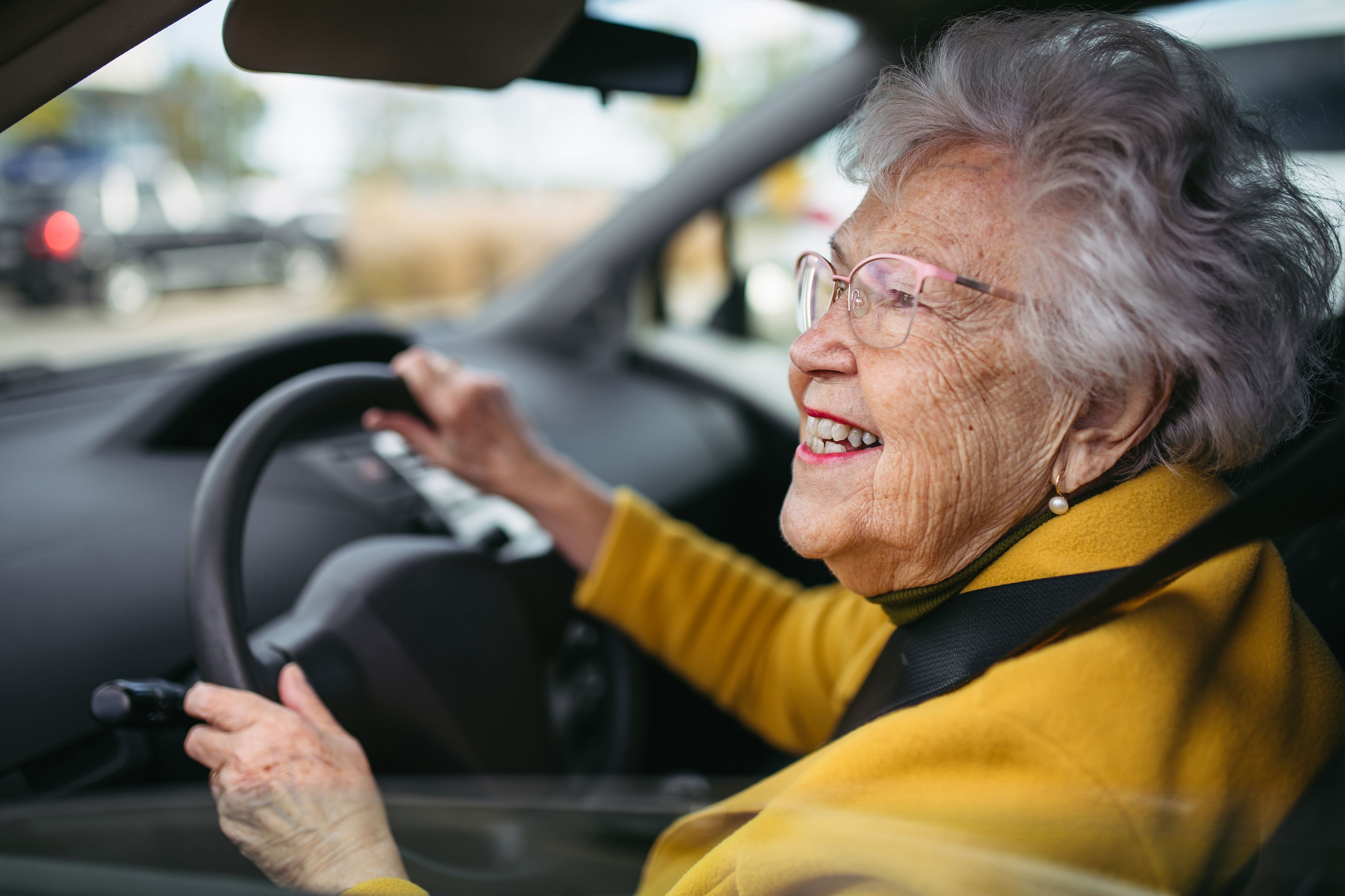Happy older woman driving car