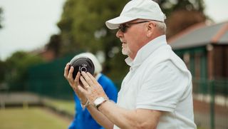 Older person playing lawn bowls