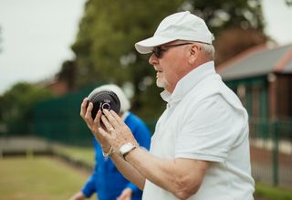 Older person playing lawn bowls